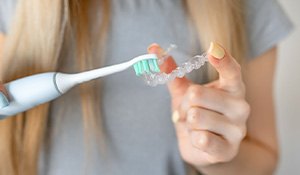 Brushing clear aligner with an electric toothbrush