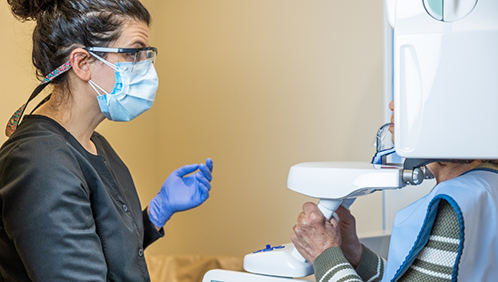 Dental team member taking a CT cone beam scan of a patient's teeth