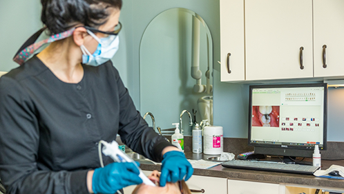 Dental team member taking impressions of a patient's teeth