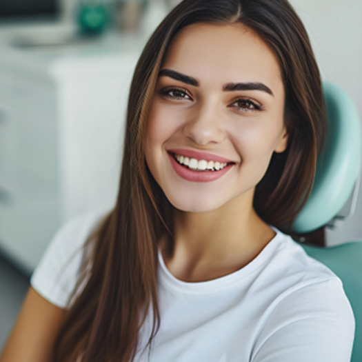 Woman sitting in dental chair and smiling