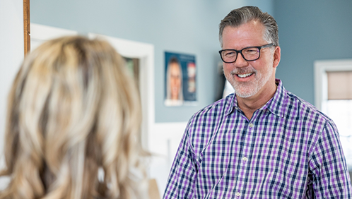 Man smiling at a dental office receptionist
