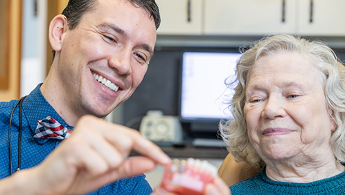 Doctor Parry showing a denture to a patient