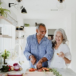 A smiling elderly couple cooking in the kitchen