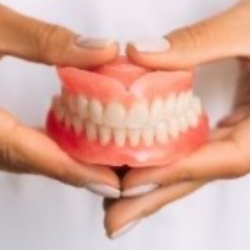 Dentist holding a full denture