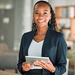Woman smiling while holding tablet in office