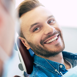 Man smiling while sitting in treatment chair