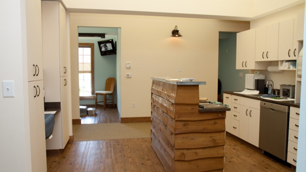 Hallway looking into dental treatment room lab and storage area