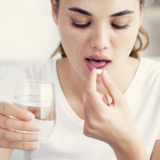 Woman taking antibiotic pill