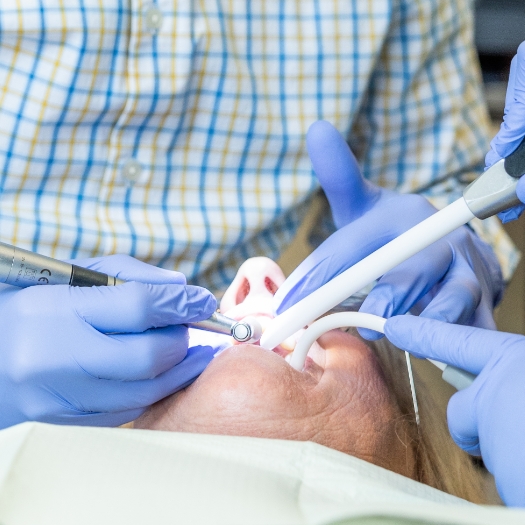 Dentist performing periodontal surgery