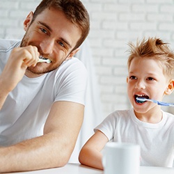 Father and son brushing to prevent dental emergencies in Summerfield