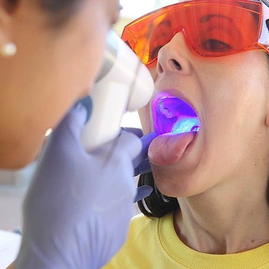 Dentist performing oral cancer screening