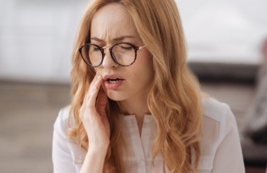 Woman in need of emergency dentistry holding jaw