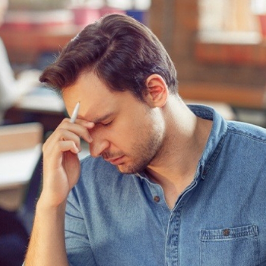 Tired man in need of sleep apnea therapy holding head