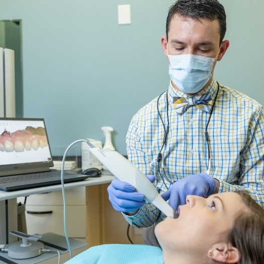 Dentist using intraoral camera to capture images of smile