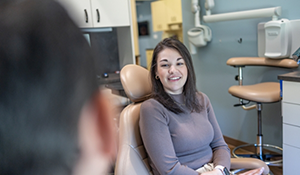 Woman in the dental chair talking with her dentist