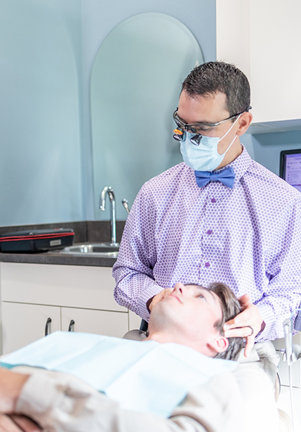 Doctor Parry examining a dental patient before TMJ treatment in Summerfield