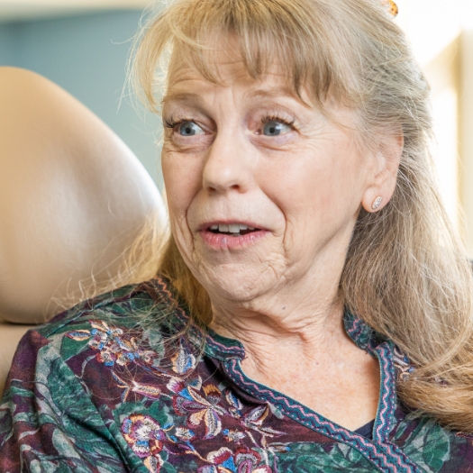 woman in red shirt trying on veneers in dental chair 