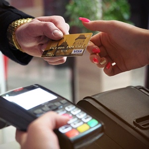 Man handing a credit card to a woman