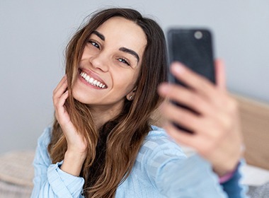 Woman chatting with dentist using her smartphone