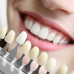 A woman selecting a shade of color for teeth whitening