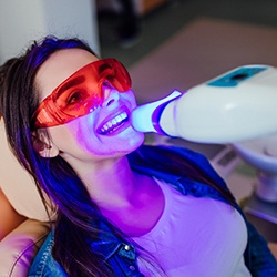 A young woman getting teeth whitening at a dentist’s office
