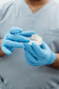 Dentist holding model explaining Invisalign in Summerfield