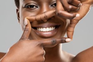 woman holding up her hands around her teeth