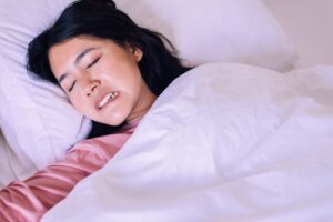 a woman grinding her teeth while sleeping
