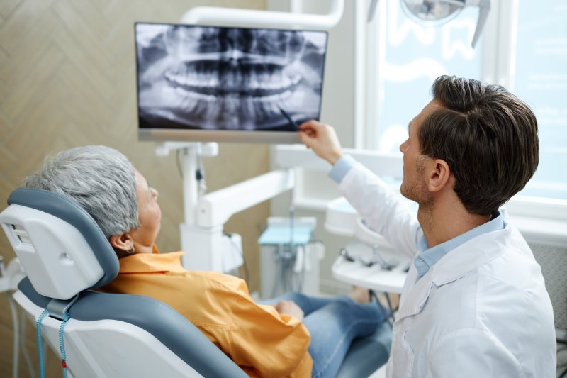 Patient smiling with their dentist as they discuss X-rays