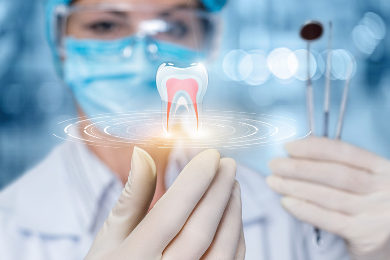 Dentist holding instruments with 3D holographic image of a tooth